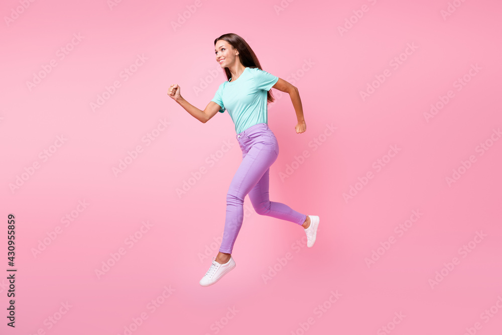 Full size profile side photo of young beautiful smiling happy woman jump look copyspace isolated on pink color background Full size profile side photo of young beautiful smiling happy woman jump look copyspace isolated on pink color background