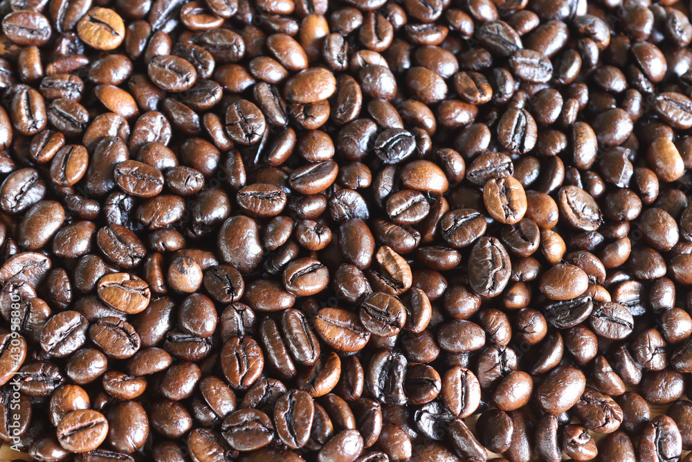 Fototapeta premium Coffee seeds pile backgrounds and textures background closeup.