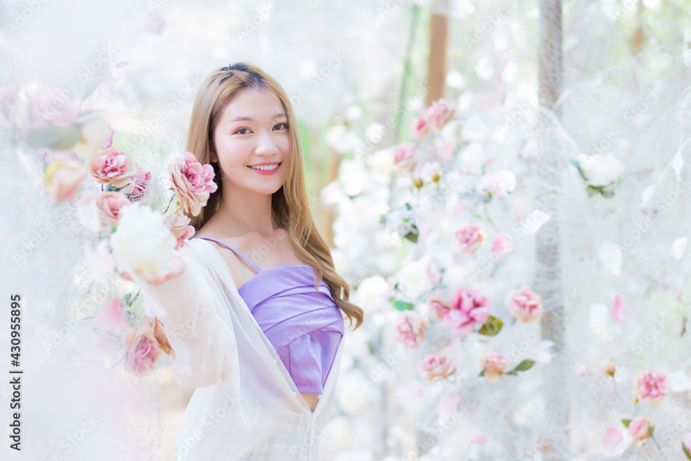 Asian beautiful girl smiles and stands in white rose flower garden as natural , luxury theme