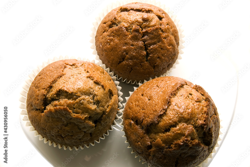 Three gingerbread muffins in cups on a plate. Three gingerbread muffins in cups on a plate.