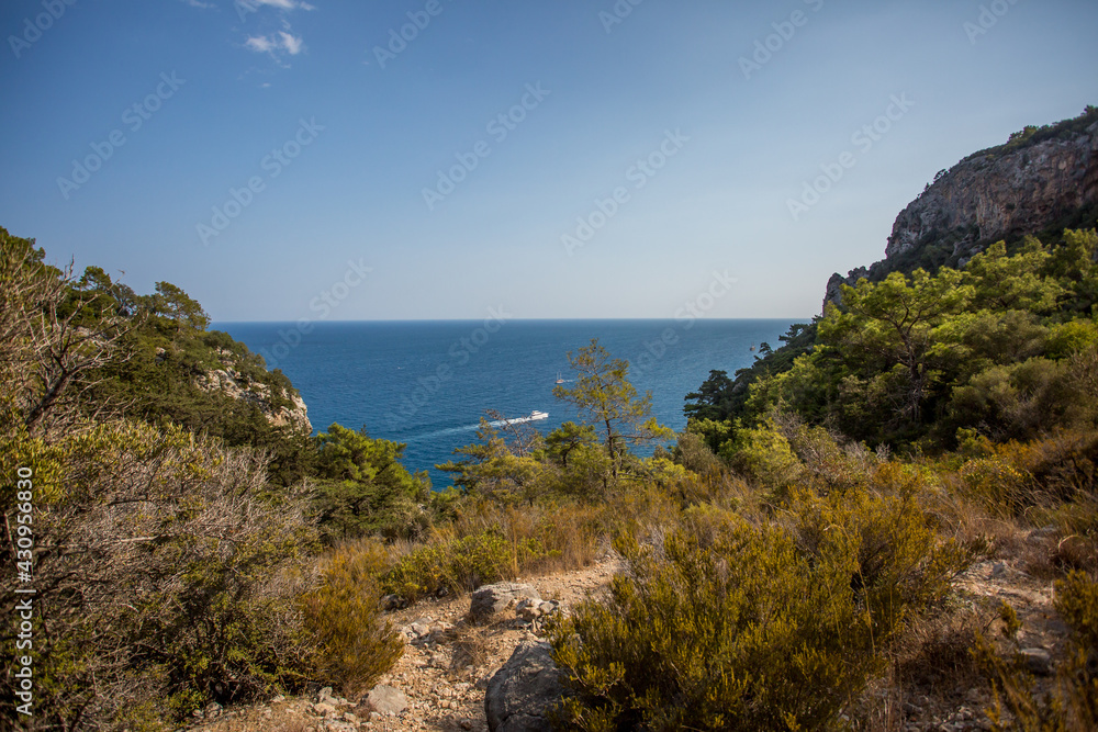 Mountain path between Kemer and Kirish. Top view from the mountain to the sea. Mountain landscape. Mountain nature. A walk in the mountain forest. Trees in the mountains.