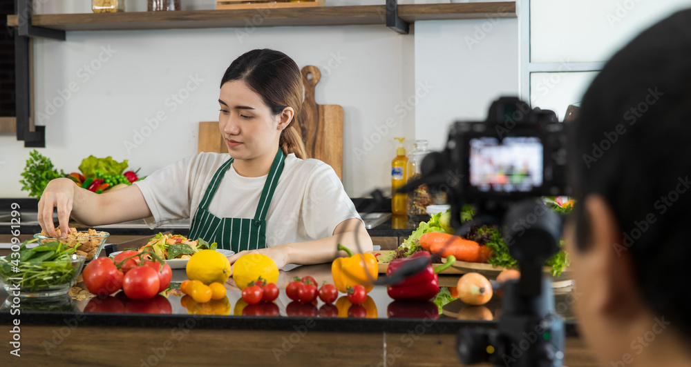 Asian food blogger cooking in front of camera Asian food blogger cooking in front of camera