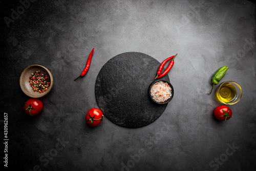 Cooking table with cutting boards herbs and spices, black background. Top view with copy space for your recipe