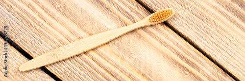 Natural eco friendly bamboo toothbrush on a wooden background. Choose a wooden toothbrush. Recycling concept, no waste, no plastic, top view