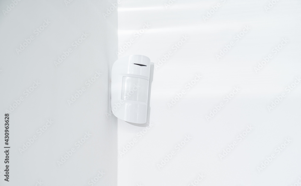 motion sensor oin the white corner. device that tracks the movement of objects. It is used to automate the operation of electrical appliances, surveillance video cameras, alarms and security system motion sensor oin the white corner. device that tracks the movement of objects. It is used to automate the operation of electrical appliances, surveillance video cameras, alarms and security system