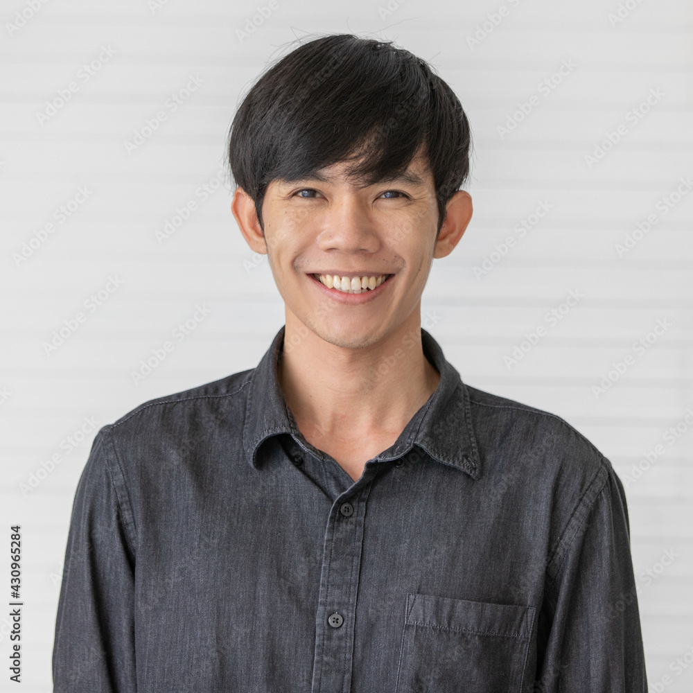 Portrait close up shot of asian male model with short black hair wearing black shirt standing in front of white background with friendly face and self confidence. Portrait close up shot of asian male model with short black hair wearing black shirt standing in front of white background with friendly face and self confidence.