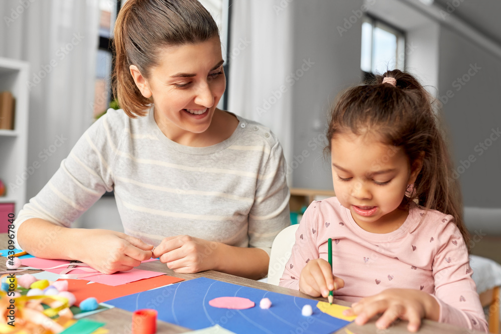 family, art and craft concept - mother spending time with her little daughter making applique of color paper at home family, art and craft concept - mother spending time with her little daughter making applique of color paper at home