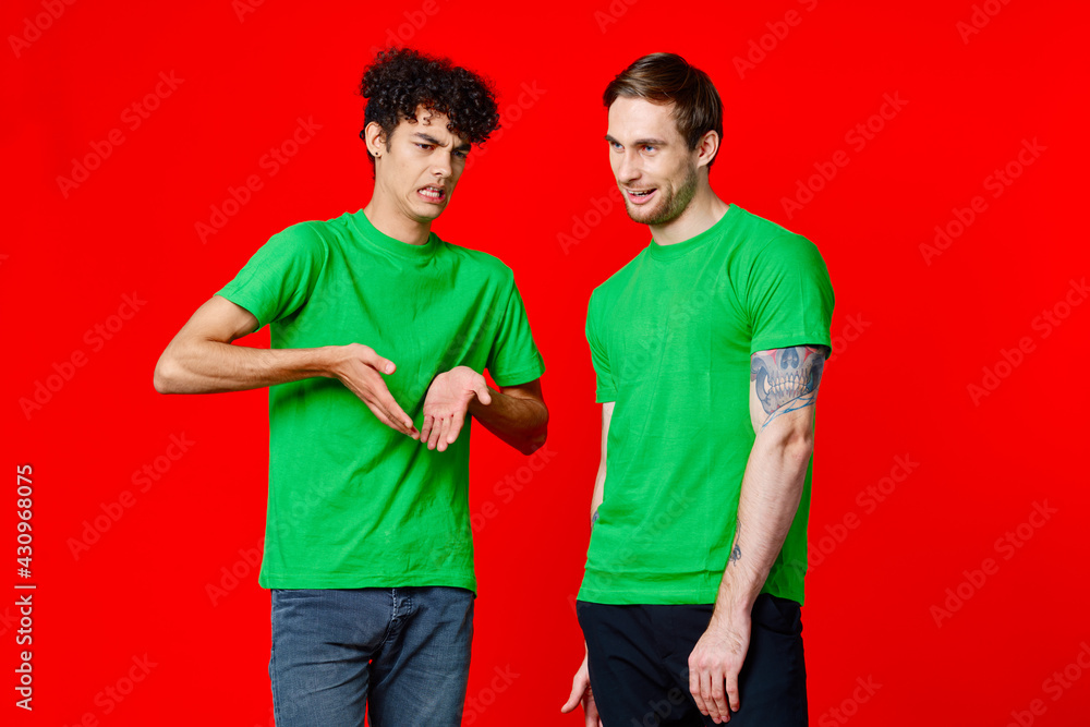 two friends in green t-shirts fun communication red background two friends in green t-shirts fun communication red background