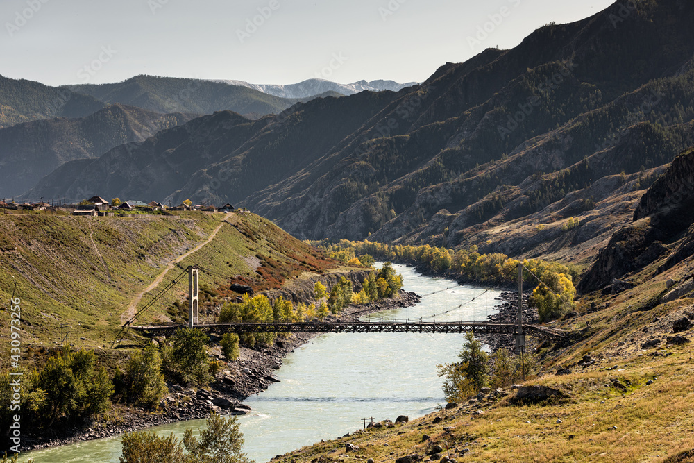 Russia, Altai, beautiful mountain landscape. River and suspension bridge