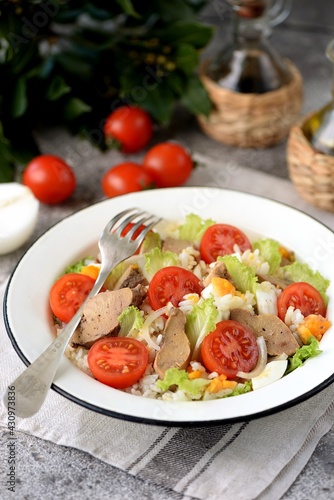 Cod liver salad with boiled eggs, cherry tomatoes, onions, lettuce and rice.