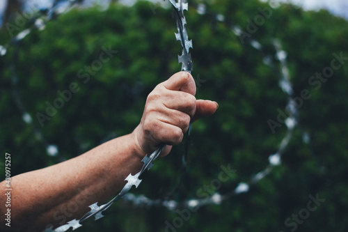 The working hand squeezes the barbed wire