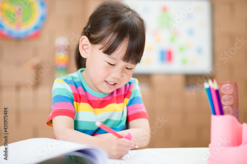 young girl practice writing letters for homeschooling
