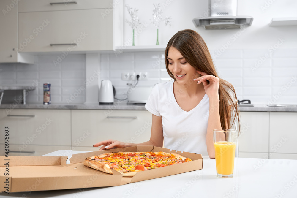 Close up of smiling woman eating delicious pizza and drinking juice. Concept of lunch at home.