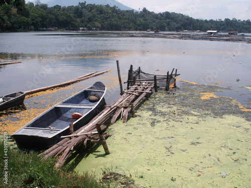 Algal bloom in a lake freshwater fishing village boat suffering from severe eutrophication. photo