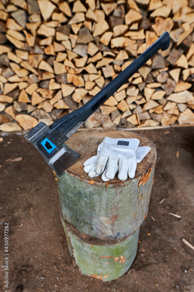 Heavy ax on the stump and protection gloves Heavy ax on the stump and protection gloves