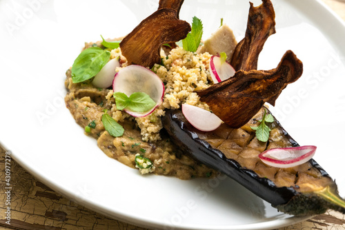Vegetarian risotto with couscous, srijemos, wild mushrooms, eggplant, celery, grana padanoi fried zucchini served in the restaurant dish on the menu
