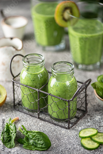 Healthy spinach, cucumber, kiwi, parsley smoothie with mineral water.