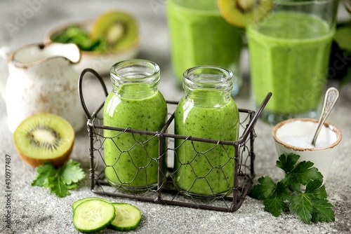 Healthy spinach, cucumber, kiwi, parsley smoothie with mineral water.