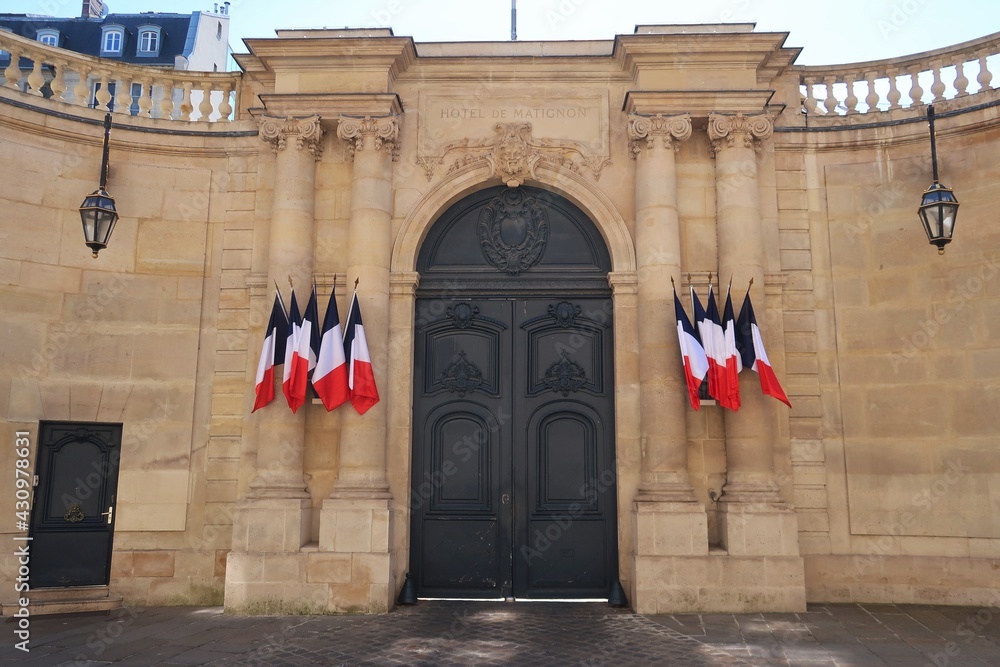 Portail d'entrée de l'hôtel de Matignon, palais de résidence officielle du Premier Ministre français, rue de Varenne à Paris, avec plusieurs drapeaux français (France) - obrazy, fototapety, plakaty 
