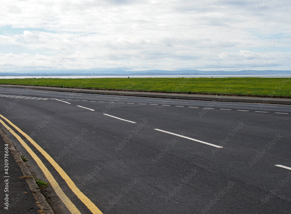 The coast road at crosby in merseyside with grass surrounding the sea at the mouth of the river mersey The coast road at crosby in merseyside with grass surrounding the sea at the mouth of the river mersey