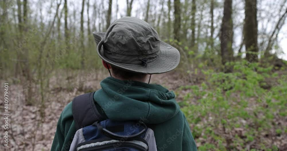 Boy is hiking in forest. The boy is walking alone in the woods, shooting from behind, Slow motion. Boy is hiking in forest. The boy is walking alone in the woods, shooting from behind, Slow motion.