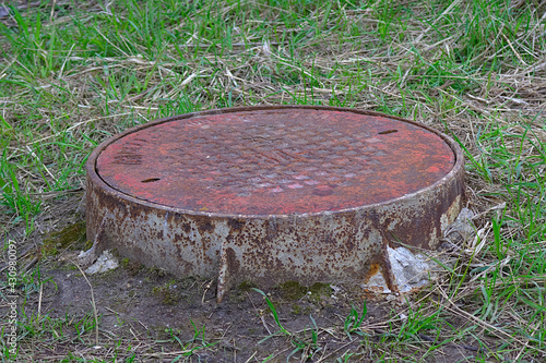 Sewer manhole on the grass lawn