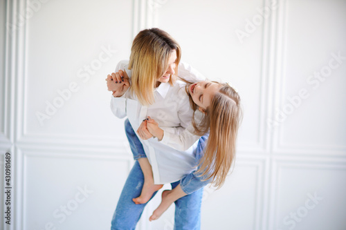 Portrait of little girl loving mother and holding her