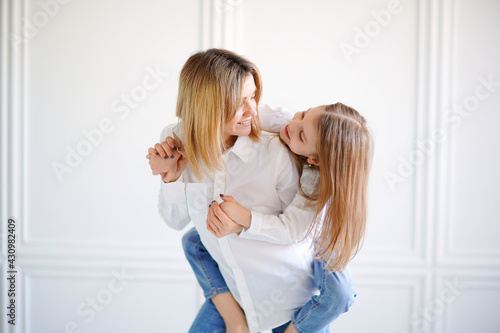 Portrait of little girl loving mother and holding her