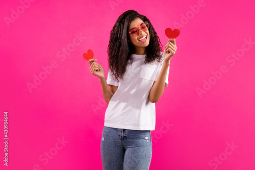 Canvas Print Portrait of pretty trendy cheerful girl holding in hands small little heart card