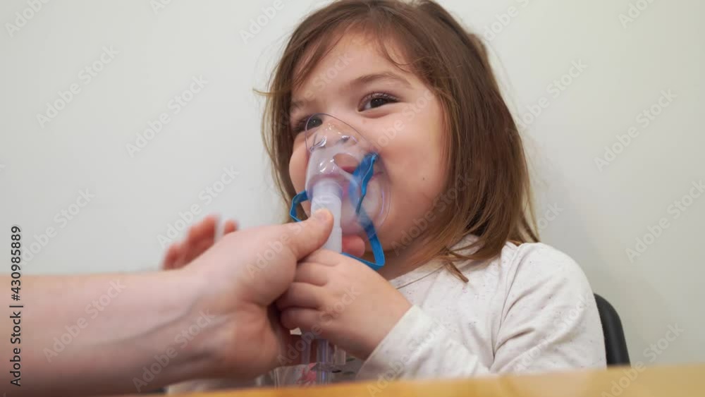 Toddler girl with oxygen nebuliser treatment at home. Inhaler therapy