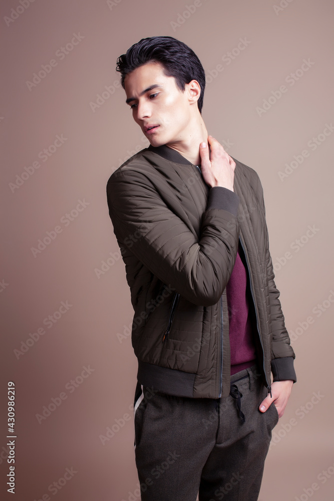 young pretty asian man posing in fashion style on light brown background, lifestyle people concept young pretty asian man posing in fashion style on light brown background, lifestyle people concept