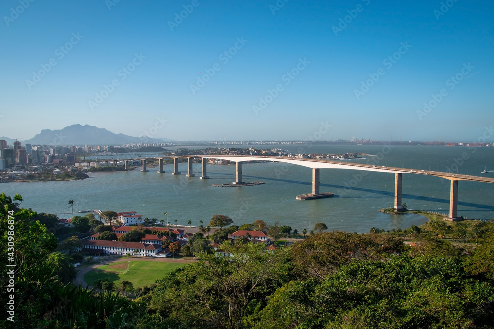 aerial view of a bridge over the sea with beach and tropical trees