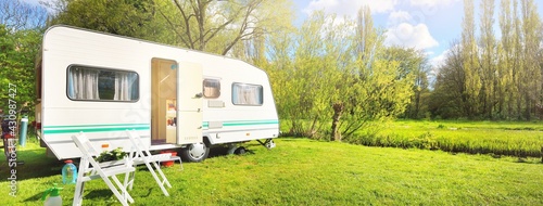 Obraz na płótnie White caravan trailer on a green lawn in a camping site