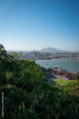aerial view of a condominium building and a bridge over the sea with beach and tropical trees © tobias