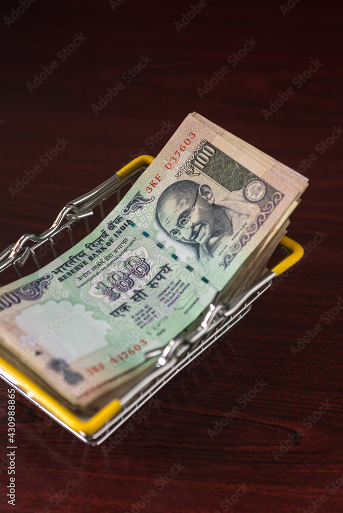 Hundred Indian rupee notes stacked in a shopping basket. Indian currency notes. Hundred Indian rupee notes stacked in a shopping basket. Indian currency notes.