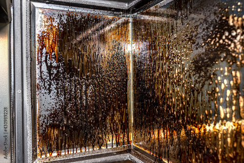 Принти на полотні Cleaning the corner glass from soot in a modern fireplace with a closed combustion chamber standing in the living room, painted black