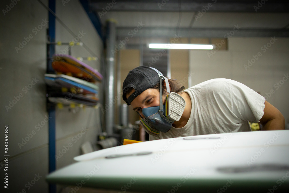 shaper modeling a new surf board