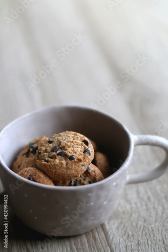 Bowl of chocolate chip cookies on wooden table. Selective focus.