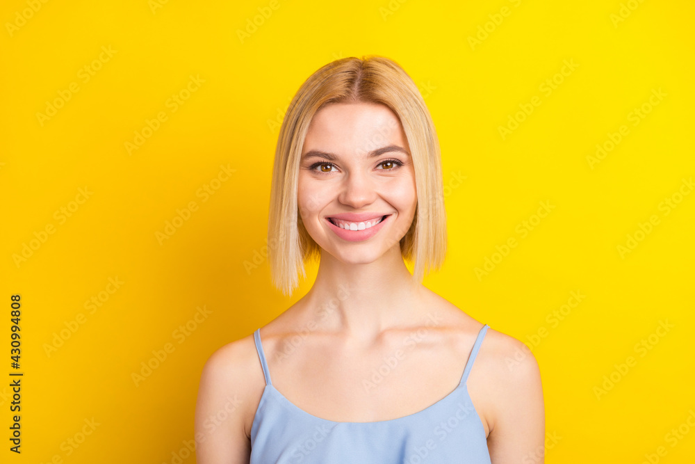 Photo of cheerful blond short hair lady wear blue top isolated on vivid yellow color background Photo of cheerful blond short hair lady wear blue top isolated on vivid yellow color background