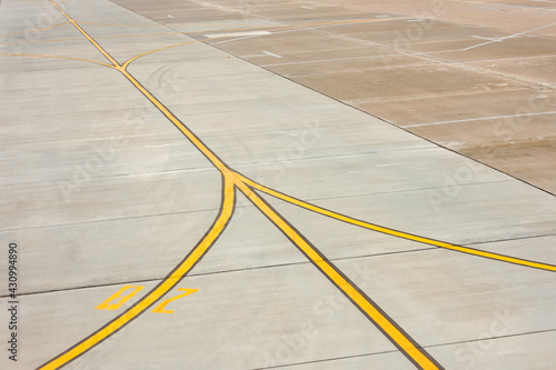Airport yellow taxiway lines markings on the apron on concrete asphalt, sign for airplane pilots.