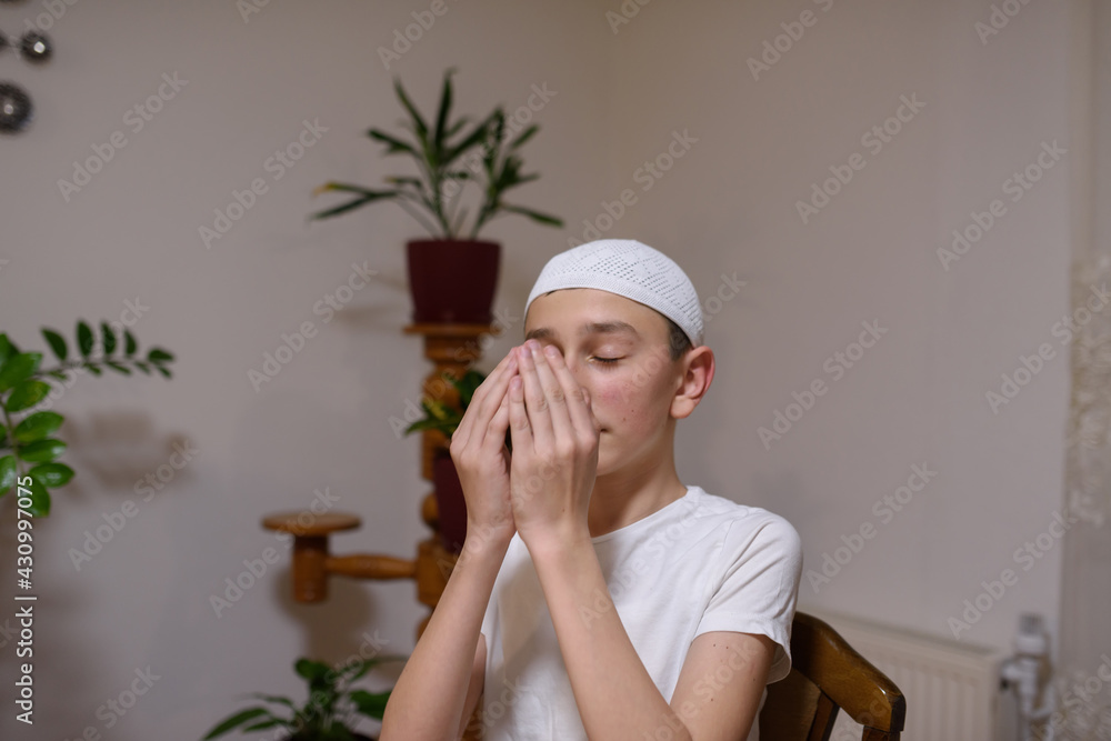 Young Muslim boy praying to Allah while waiting for iftar in Ramadan. Young Muslim boy praying to Allah while waiting for iftar in Ramadan.