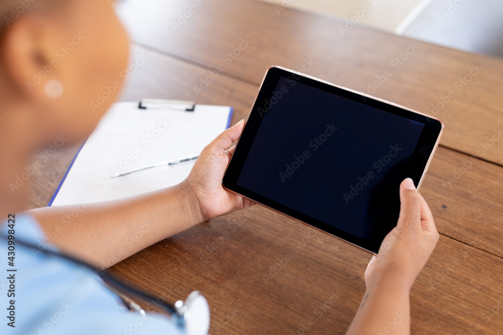 African american female doctor giving video call consultation using tablet, copy space on screen African american female doctor giving video call consultation using tablet, copy space on screen