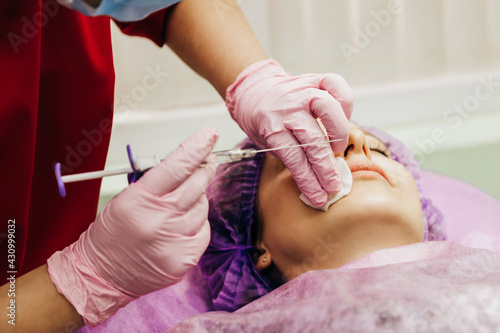 The doctor cosmetologist makes Lip augmentation procedure of woman © Julia Kiseleva