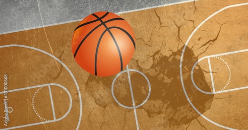 Composition of basketball in air over basketball court cracked distressed surface