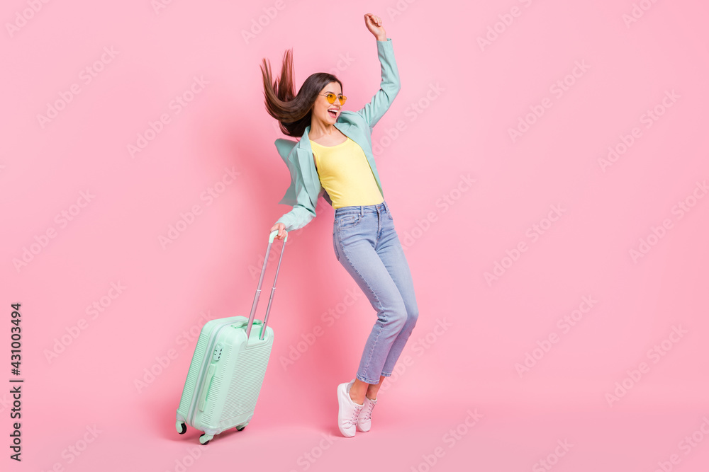 Full size profile side photo of attractive amazed woman look empty space hold luggage isolated on pink color background Full size profile side photo of attractive amazed woman look empty space hold luggage isolated on pink color background