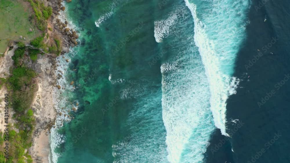 View from the top is beautiful ocean waves splashing towards a beautiful rocky island covered with greenery on a sunny summer day. Ocean beauty and vastness concept View from the top is beautiful ocean waves splashing towards a beautiful rocky island covered with greenery on a sunny summer day. Ocean beauty and vastness concept