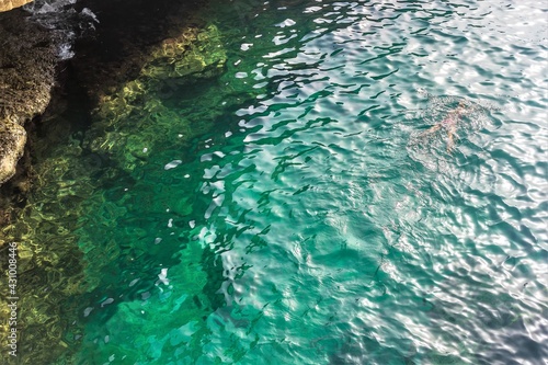 Fototapeta Naklejka Na Ścianę i Meble -  Malta, Marsaxlokk, August 2019. Silhouette of a man swimming under water.
