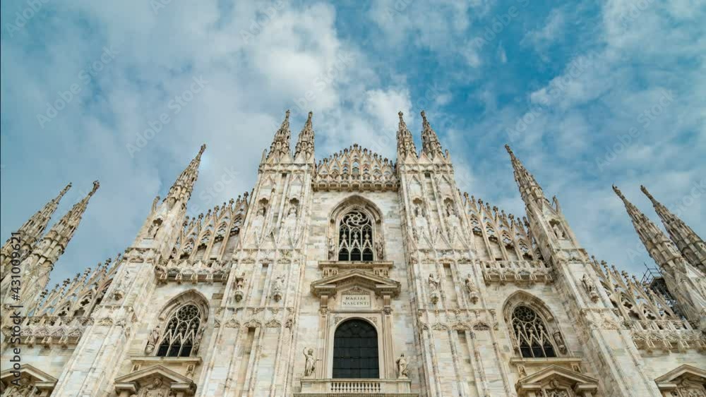 The facade of the famous Milan gothic Cathedral (also known as Duomo), Italy. It is a classic point of interest in travel and for religion. Moving clouds on the background. Time lapse. The facade of the famous Milan gothic Cathedral (also known as Duomo), Italy. It is a classic point of interest in travel and for religion. Moving clouds on the background. Time lapse.