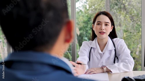 A friendly Asian female doctor or nurse with a stethoscope is talking or explain information to an Asian male patient, ideas for healthcare concepts.	