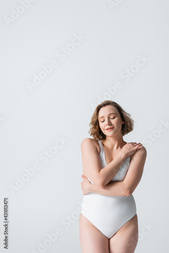 dreamy overweight woman with closed eyes posing isolated on white